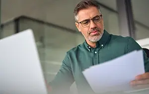 HR professional reviewing contracts and policies for errors.